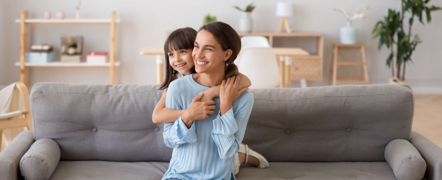 mother and daughter embrace on couch