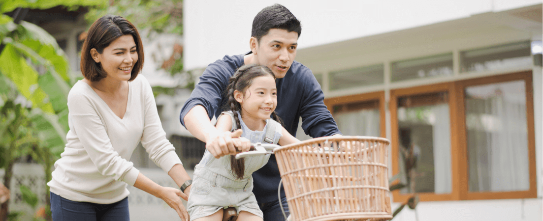 parents teach daughter to ride a bike