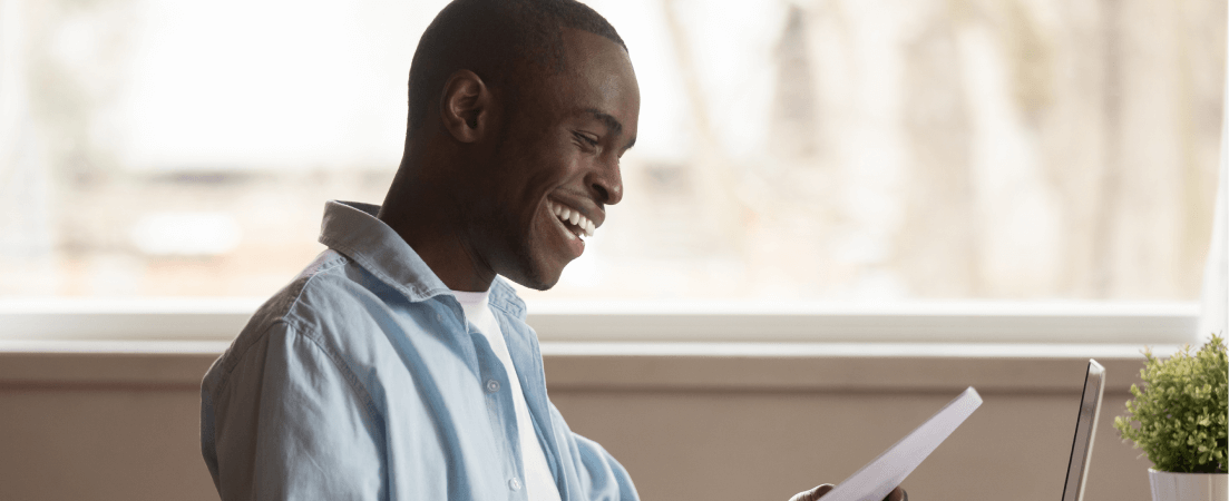 a man holds a piece of paper and smiles