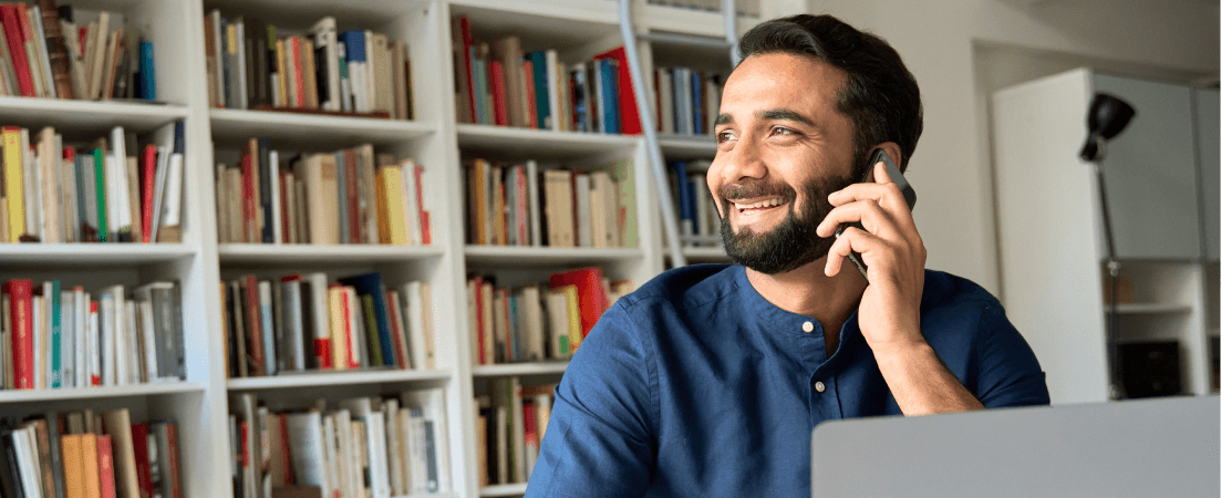 smiling man on phone at computer