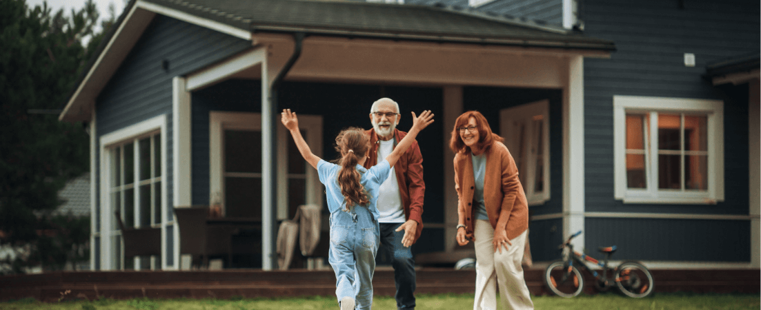 Granddaughter running to grandparents in front of their house