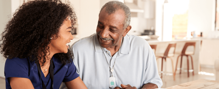 An older man and a younger woman sit together smiling
