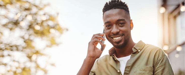 Smiling man on his phone outside