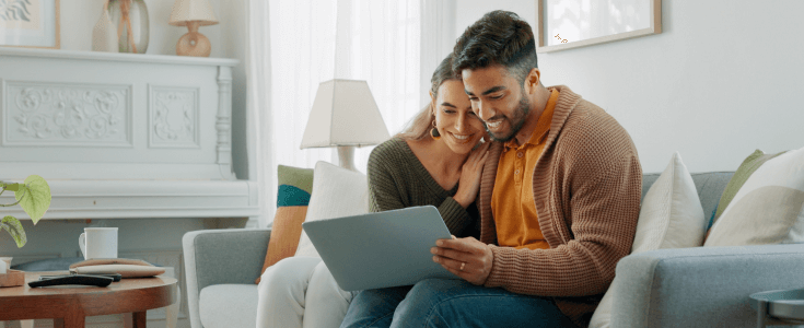 couple looking at laptop on the couch