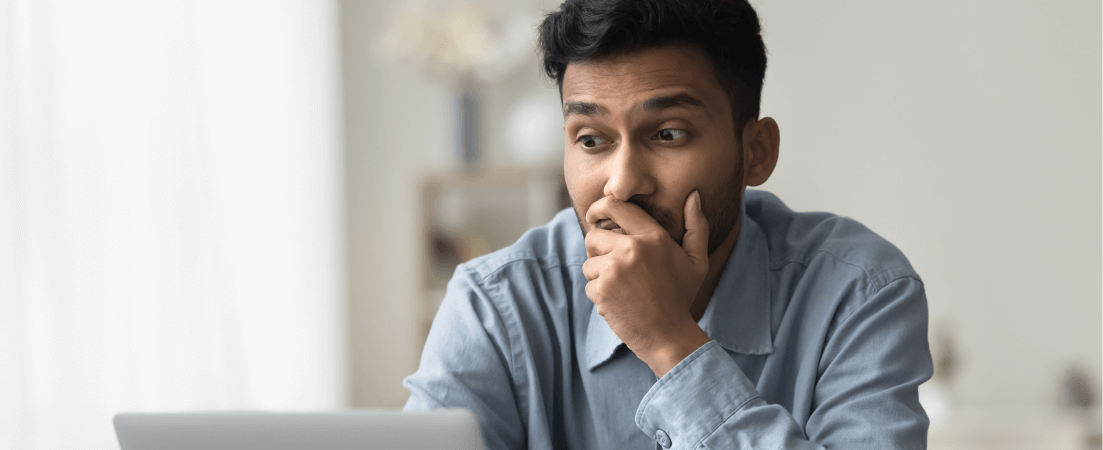 Man looks at his laptop worried