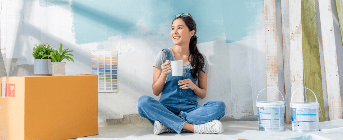 A woman takes a break while repainting her house
