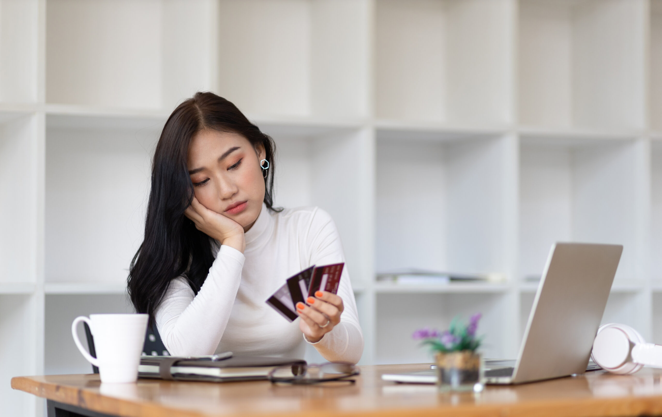 worried woman holding credit cards